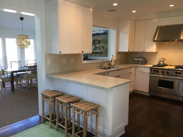 a kitchen that has a sink a stove and cabinets