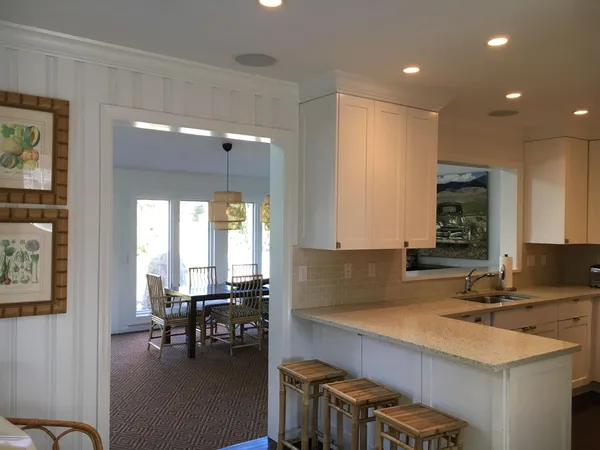 a kitchen with a sink a stove and chairs