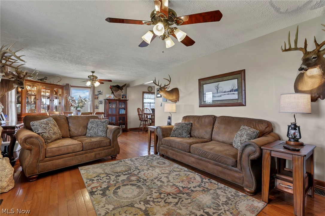 5502 Dutch Ridge Road New Straitsville, OH 43766 - Photo 14 of 49 Living room with wood-type flooring, a textured ceiling, and ceiling fan