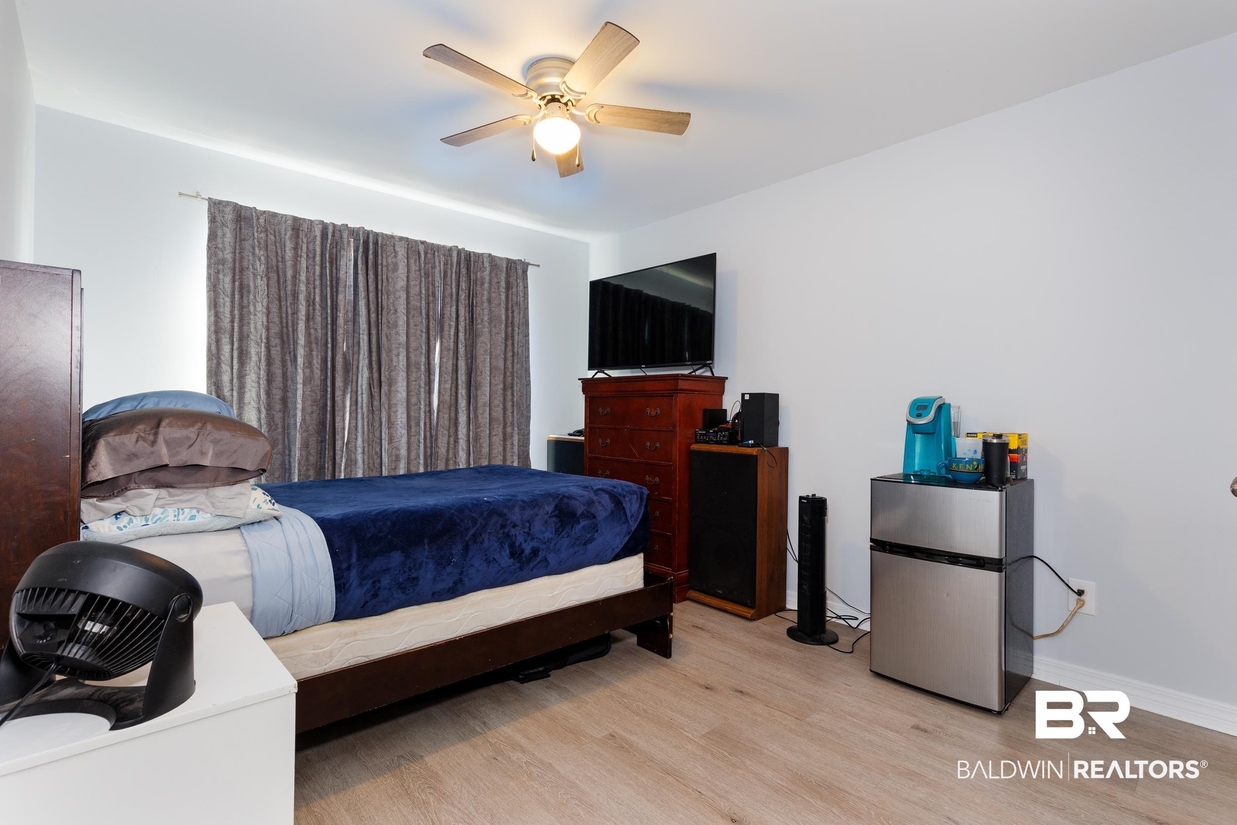 16227 Zenith Drive Loxley, AL 36551 - Photo 15 of 23 Bedroom featuring freestanding refrigerator, light wood-style flooring, and a ceiling fan