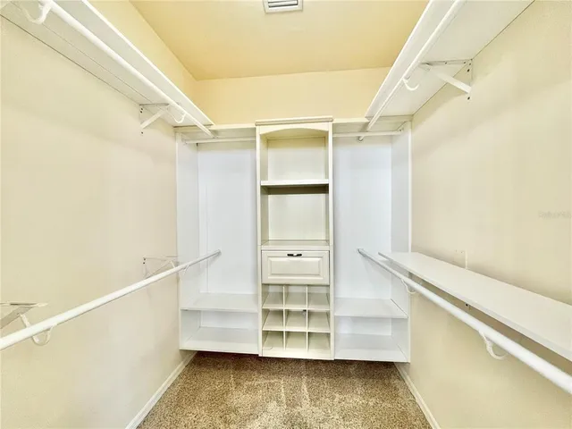 an empty room with a chandelier fan and closet