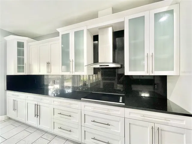 a kitchen with stainless steel appliances kitchen island granite countertop white cabinets and sink