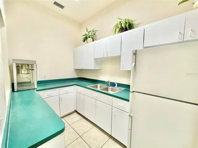 a kitchen with stainless steel appliances kitchen island granite countertop a refrigerator and a stove top oven