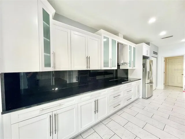 a kitchen with granite countertop white cabinets and stainless steel appliances