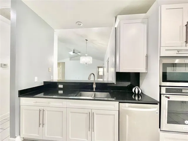 a kitchen with stainless steel appliances a refrigerator sink and white cabinets