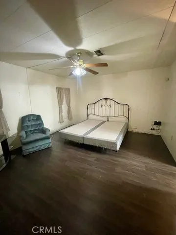 a spacious bedroom with a bed a couch and a chandelier