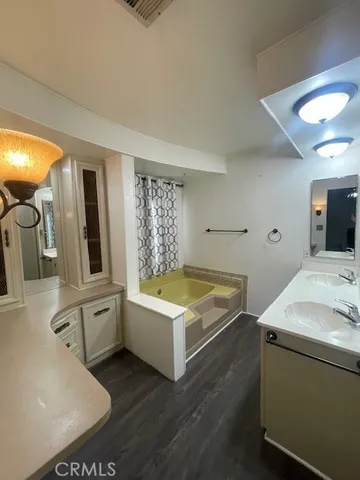 a bathroom with a tub sink and mirror