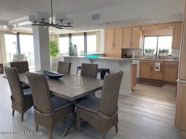 a kitchen with a table chairs a sink dishwasher window and cabinets