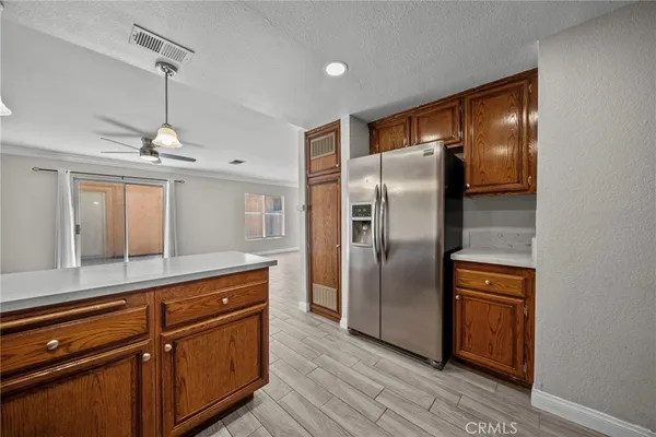a kitchen with kitchen island a counter top space wooden floor and stainless steel appliances