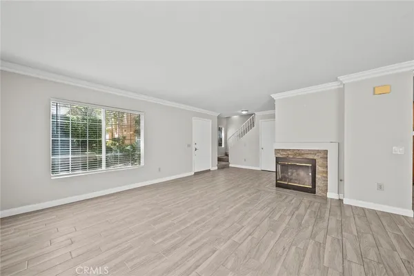 an empty room with windows and a fireplace