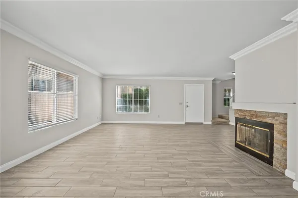 wooden floor fireplace and windows in an empty room