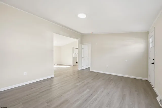 a view of an empty room with wooden floor