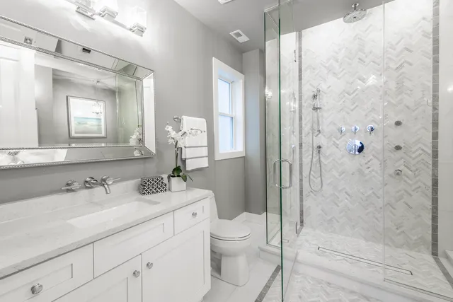 a bathroom with a sink a toilet and shower