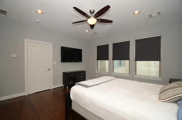 a bedroom with a bed large window and a flat screen tv