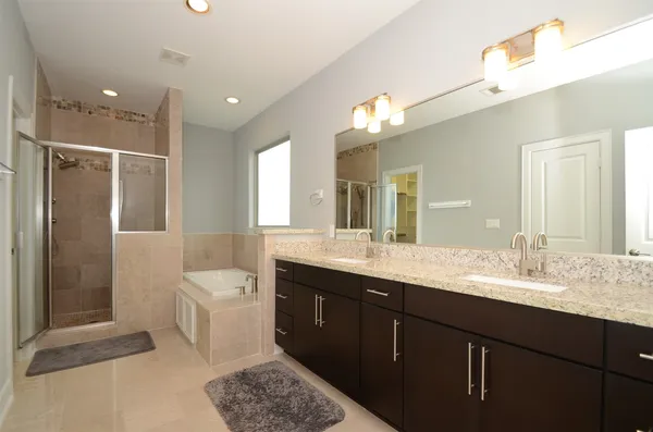 a bathroom with a double vanity sink mirror double and shower