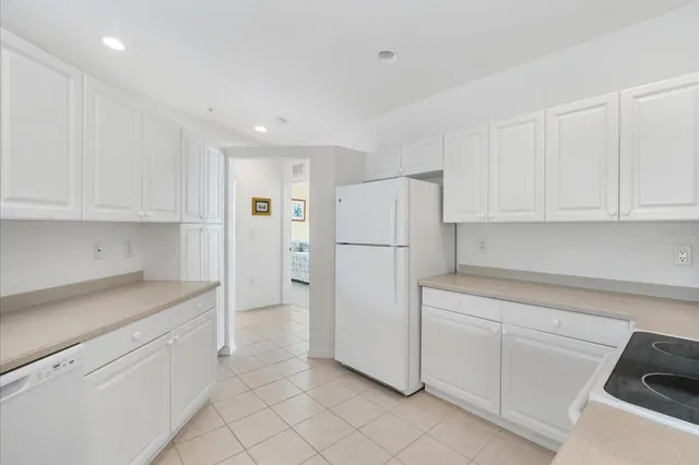 a kitchen with white cabinets and refrigerator