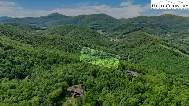 a view of a lush green hillside and mountains