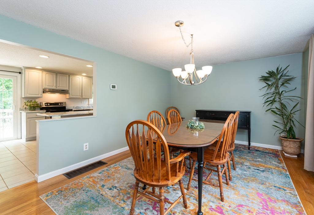 11 Emerson Road Nashua, NH 03062 - Photo 13 of 35 a dining room with furniture a chandelier and wooden floor
