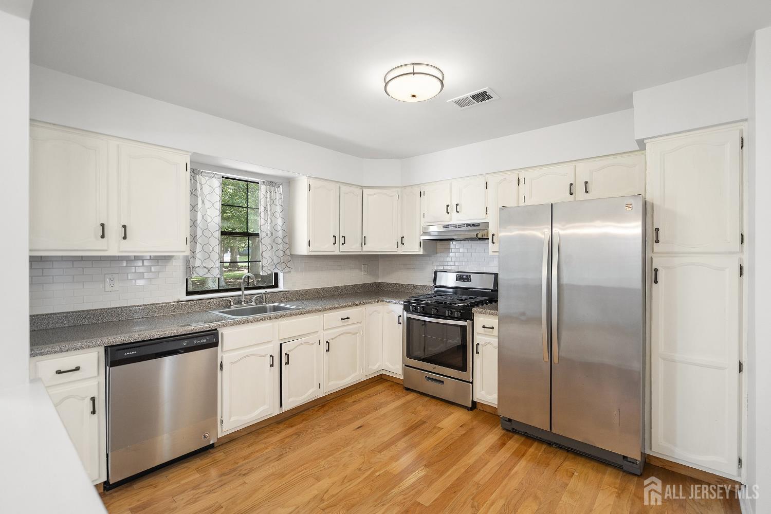 804 Timber Oaks Road Edison, NJ 08820 - Photo 11 of 26 a kitchen with stainless steel appliances granite countertop a refrigerator a sink dishwasher a stove top oven a refrigerator with white cabinets and wooden floor