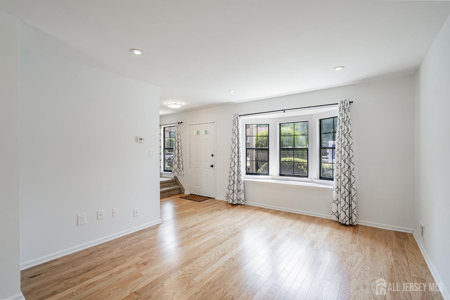 804 Timber Oaks Road Edison, NJ 08820 - Photo 7 of 26 an empty room with wooden floor and windows
