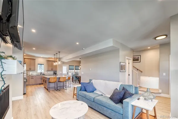 a living room with furniture and a view of kitchen