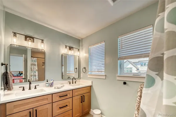 a bathroom with double vanity sink a mirror and a window