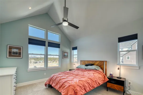 a bedroom with a large bed and a chandelier