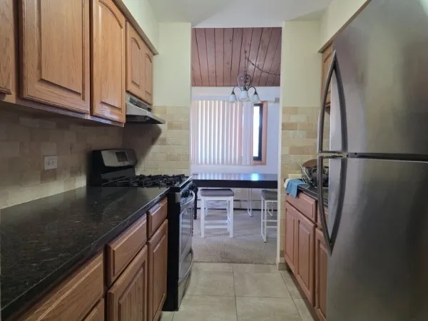 a kitchen with a sink a refrigerator and cabinets