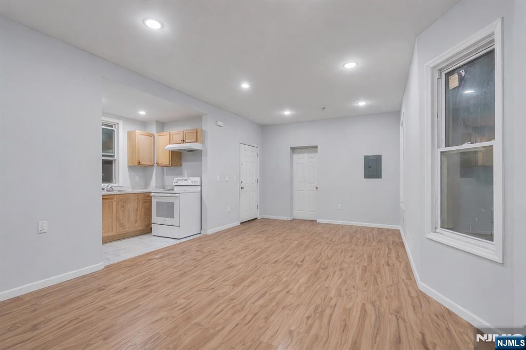 90 Park Avenue Paterson, NJ 07501 - Photo 12 of 42 a view of kitchen and empty room with wooden floor
