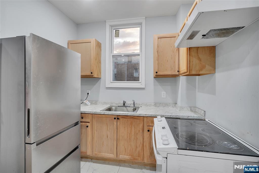 90 Park Avenue Paterson, NJ 07501 - Photo 13 of 42 a kitchen with a sink and a refrigerator