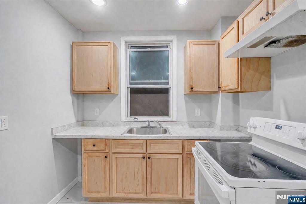 90 Park Avenue Paterson, NJ 07501 - Photo 14 of 42 a kitchen with stainless steel appliances granite countertop a sink dishwasher and cabinets with wooden floor