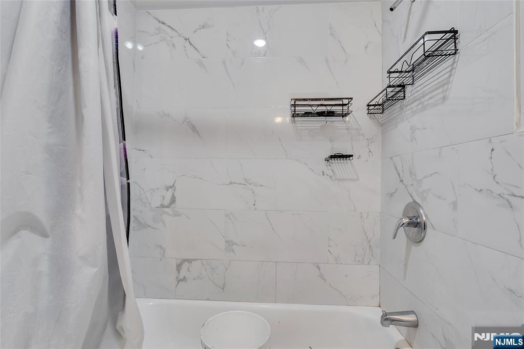 90 Park Avenue Paterson, NJ 07501 - Photo 25 of 42 a bathroom with a shower and a bathtub
