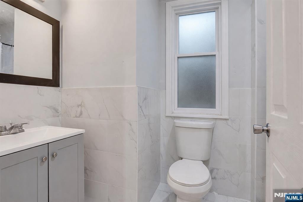 90 Park Avenue Paterson, NJ 07501 - Photo 26 of 42 a bathroom with a toilet a sink and mirror