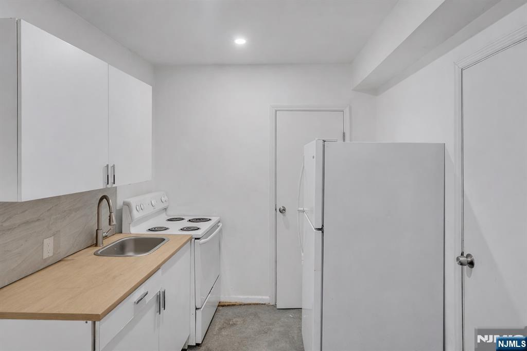 90 Park Avenue Paterson, NJ 07501 - Photo 29 of 42 a kitchen with stainless steel appliances granite countertop a sink and a refrigerator