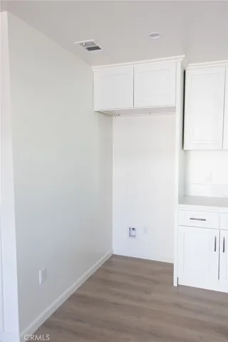 a view of a room with wooden floor and cabinet