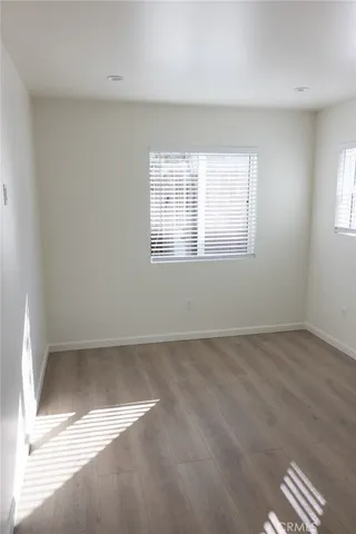 an empty room with wooden floor cabinet and closet