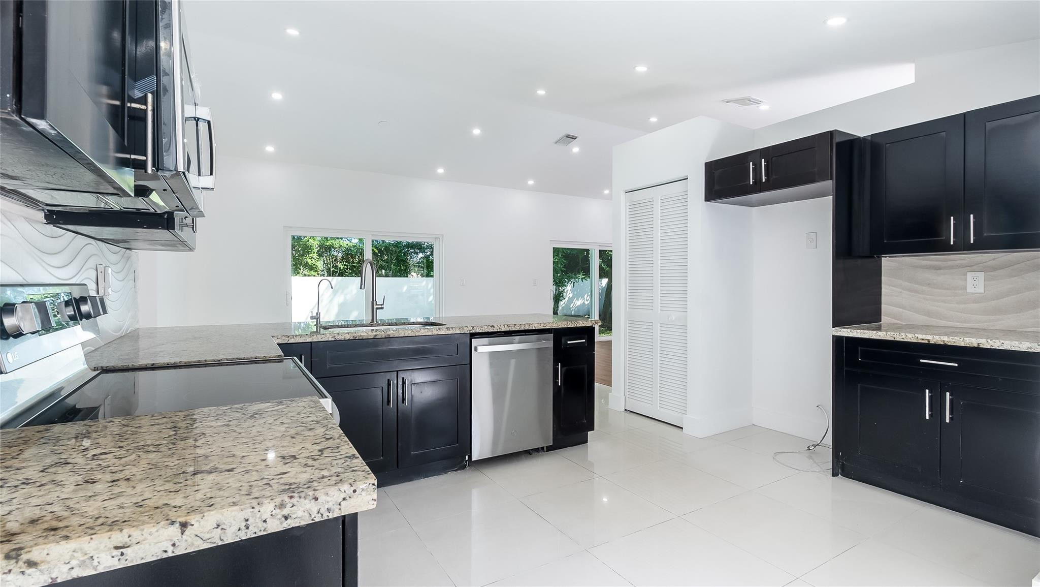 1811 Southwest 124th Way Miramar, FL 33027 - Photo 12 of 28 a kitchen with stainless steel appliances granite countertop wooden cabinets a sink and a oven