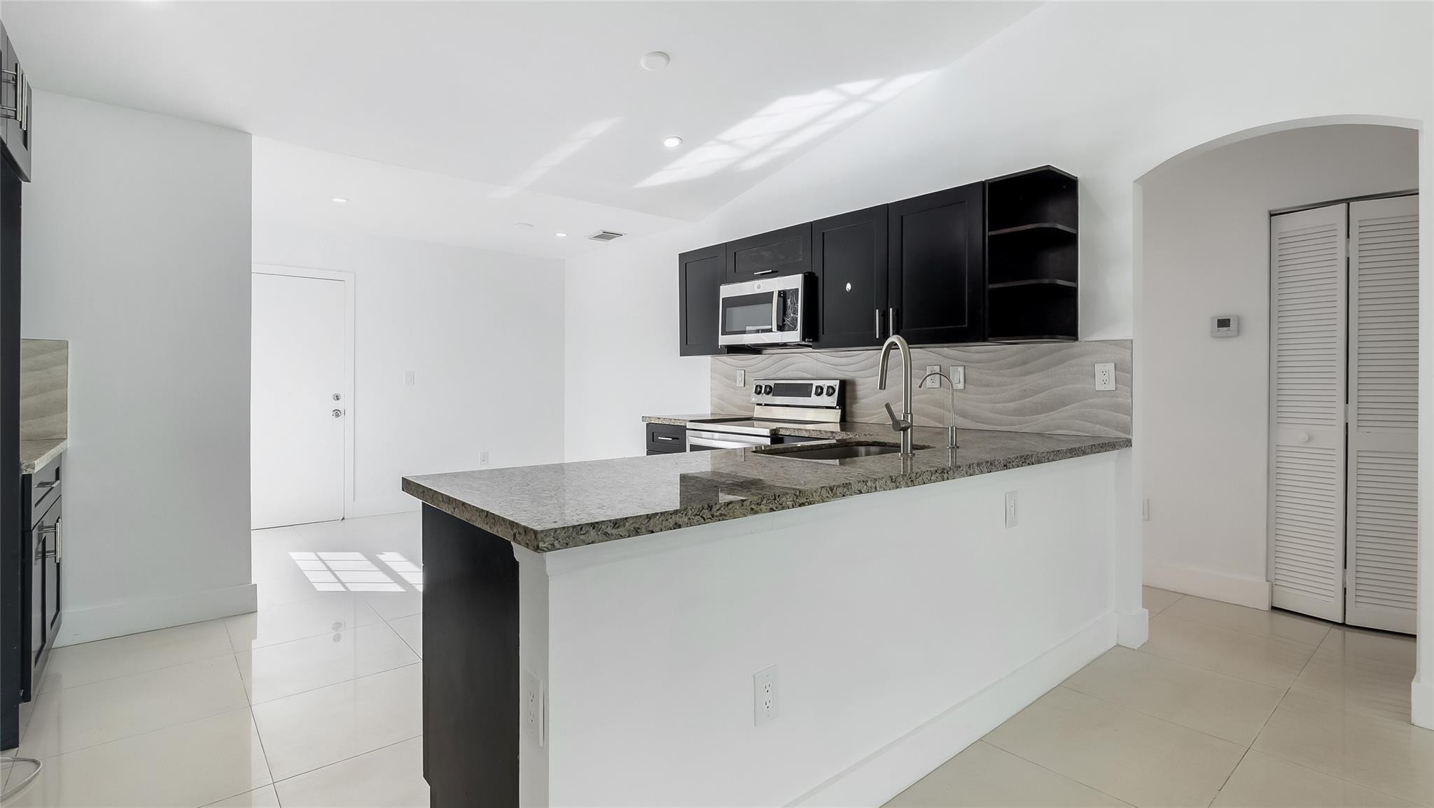 1811 Southwest 124th Way Miramar, FL 33027 - Photo 9 of 28 a kitchen with stainless steel appliances granite countertop a sink and a microwave