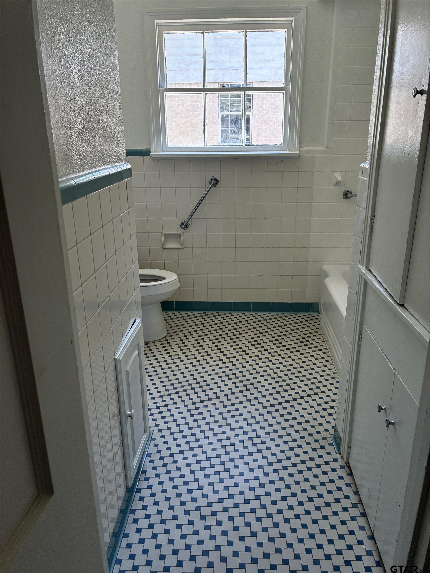 811 West 5th Street Tyler, TX 75701 - Photo 15 of 26 a bathroom with a sink a toilet a window a shower and vanity