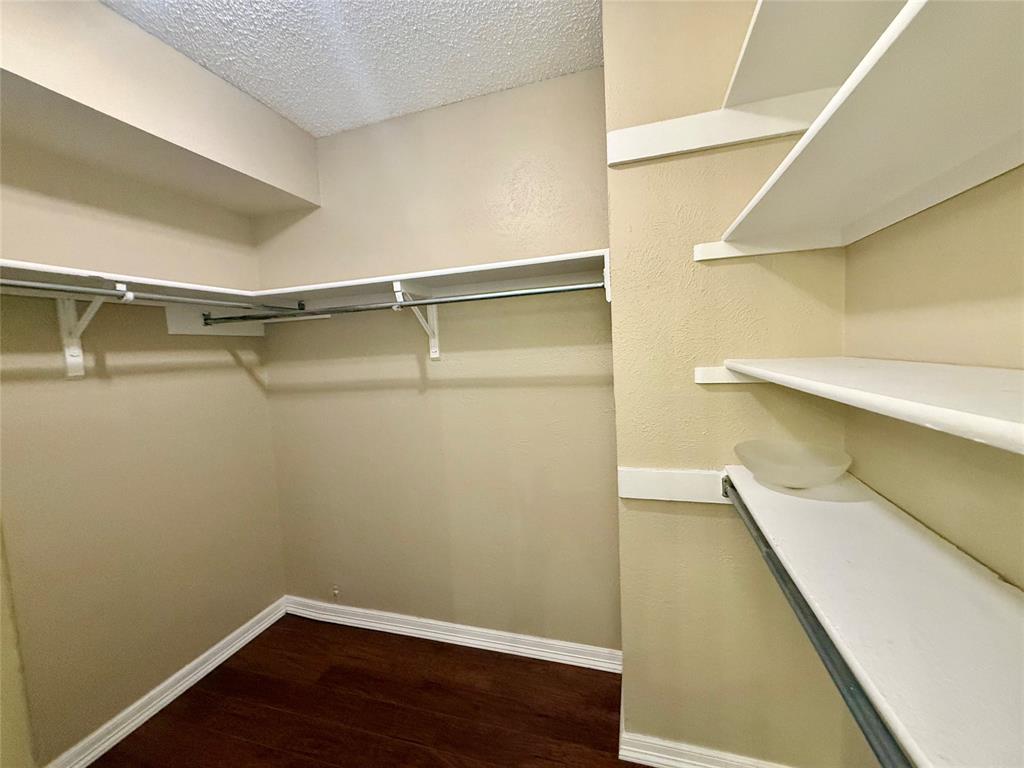 777 Custer Road, Unit 23 Richardson, TX 75080 - Photo 13 of 28 Spacious closet featuring dark wood finished floors
