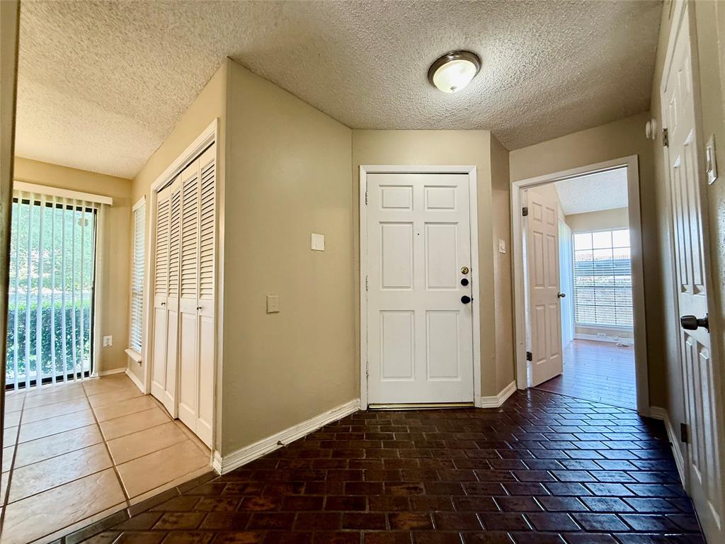 777 Custer Road, Unit 23 Richardson, TX 75080 - Photo 19 of 28 Entrance foyer featuring a textured ceiling and brick flooring
