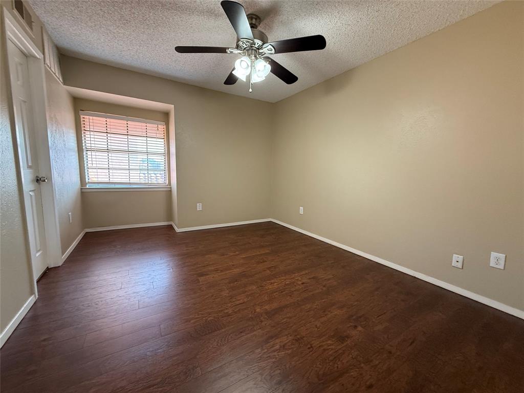 777 Custer Road, Unit 23 Richardson, TX 75080 - Photo 25 of 28 Spare room with a textured ceiling, dark wood-style floors, and a ceiling fan