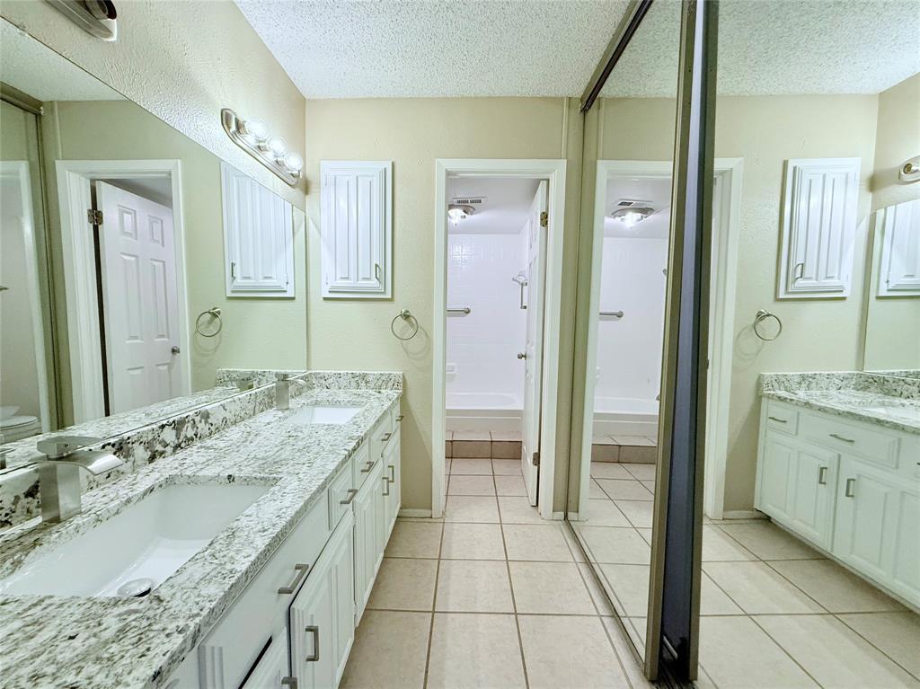 777 Custer Road, Unit 23 Richardson, TX 75080 - Photo 3 of 28 Bathroom with double vanity, light tile patterned flooring, a textured ceiling, and shower / bath combination
