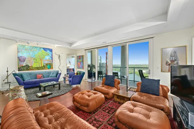 a living room with furniture a rug and a large window