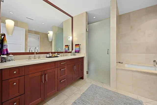 a spacious bathroom with a double vanity sink a large mirror and a shower