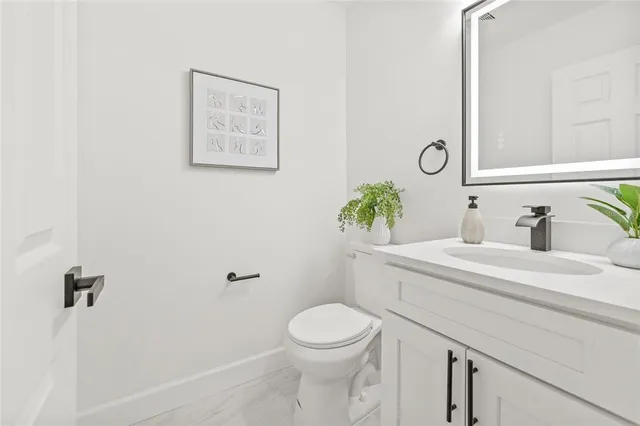 a bathroom with a sink mirror vanity and toilet
