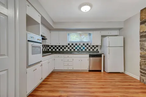 a kitchen with stainless steel appliances a refrigerator and white cabinets