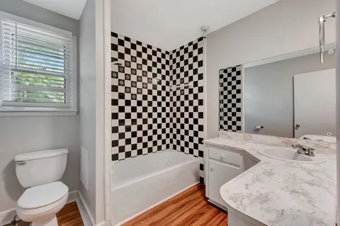 a bathroom with a sink toilet vanity and shower