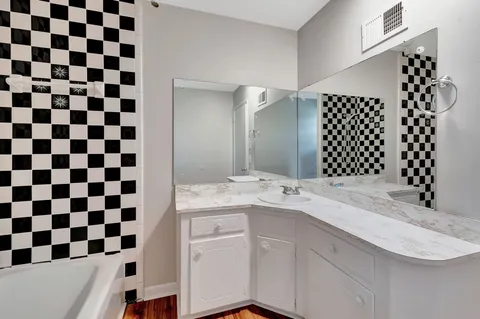 a bathroom with a granite countertop sink and a mirror