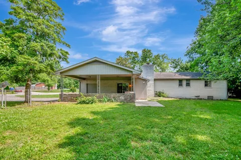 a front view of a house with a yard and trees